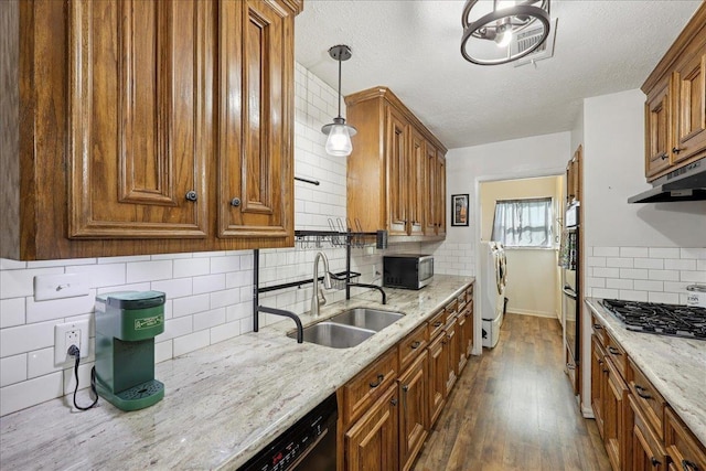 1407 N 15th St, Nederland, TX 77627 - kitchen with washer and clothes dryer, a sink, black appliances, tasteful backsplash, and brown cabinetry