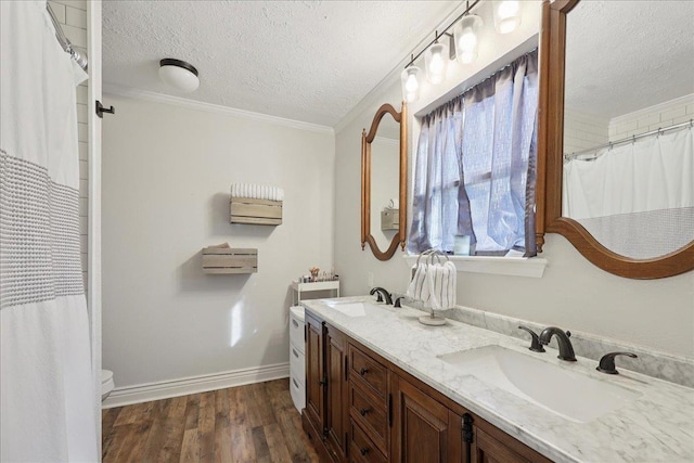 1407 N 15th St, Nederland, TX 77627 - full bathroom featuring a textured ceiling, toilet, double vanity, wood finished floors, and crown molding