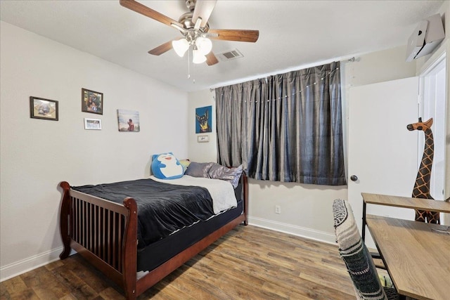 1407 N 15th St, Nederland, TX 77627 - bedroom with baseboards, a wall mounted air conditioner, wood finished floors, and a ceiling fan