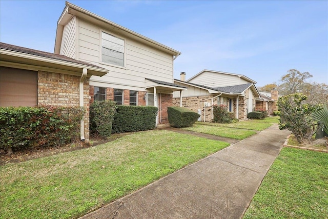 view of front of property featuring brick siding and a front yard