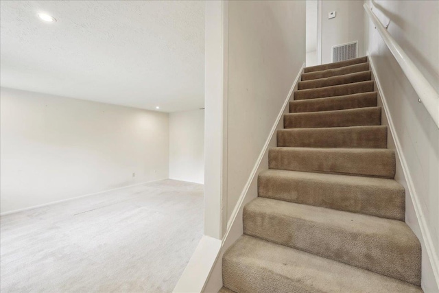 staircase featuring recessed lighting, visible vents, and carpet floors