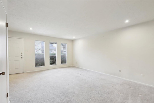 unfurnished room featuring light carpet, recessed lighting, and baseboards