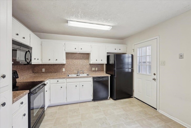 kitchen featuring black appliances, white cabinets, backsplash, and a sink