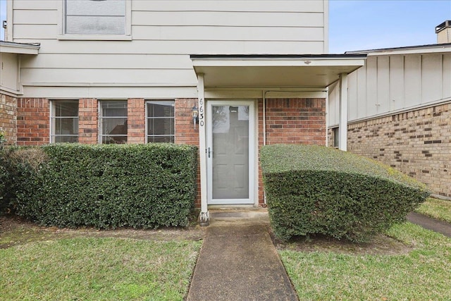 view of exterior entry featuring brick siding