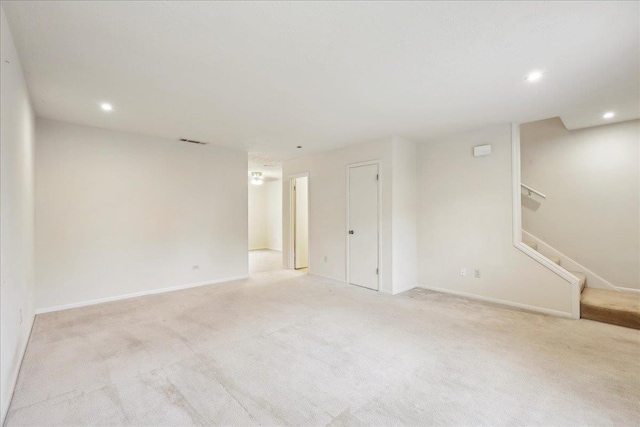 unfurnished room with visible vents, baseboards, light colored carpet, stairs, and recessed lighting