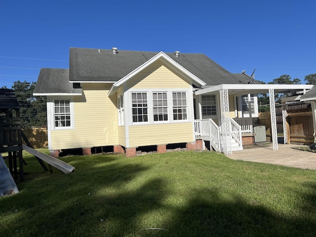 back of house featuring a lawn and a patio