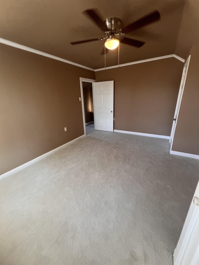 carpeted spare room with crown molding and ceiling fan