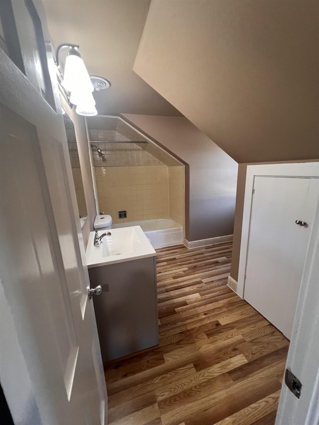 bathroom with vanity, hardwood / wood-style flooring, and tiled shower / bath combo