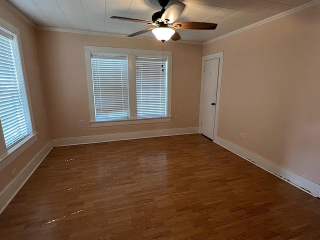 spare room featuring ceiling fan, plenty of natural light, dark wood-type flooring, and ornamental molding