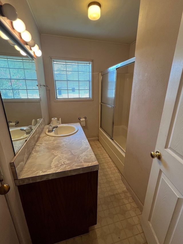 bathroom featuring a wealth of natural light, vanity, and walk in shower