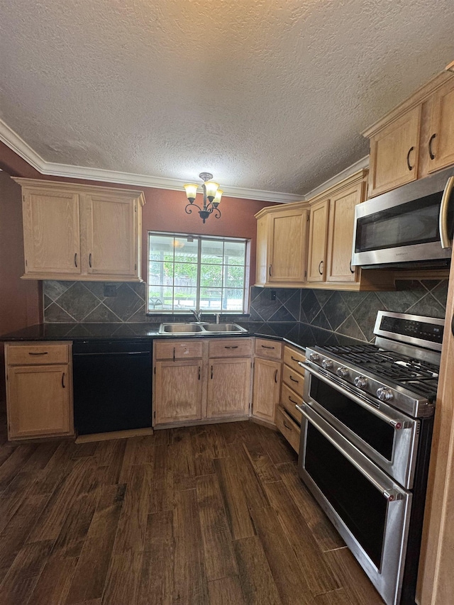 kitchen featuring dark countertops, appliances with stainless steel finishes, a sink, ornamental molding, and dark wood-style floors