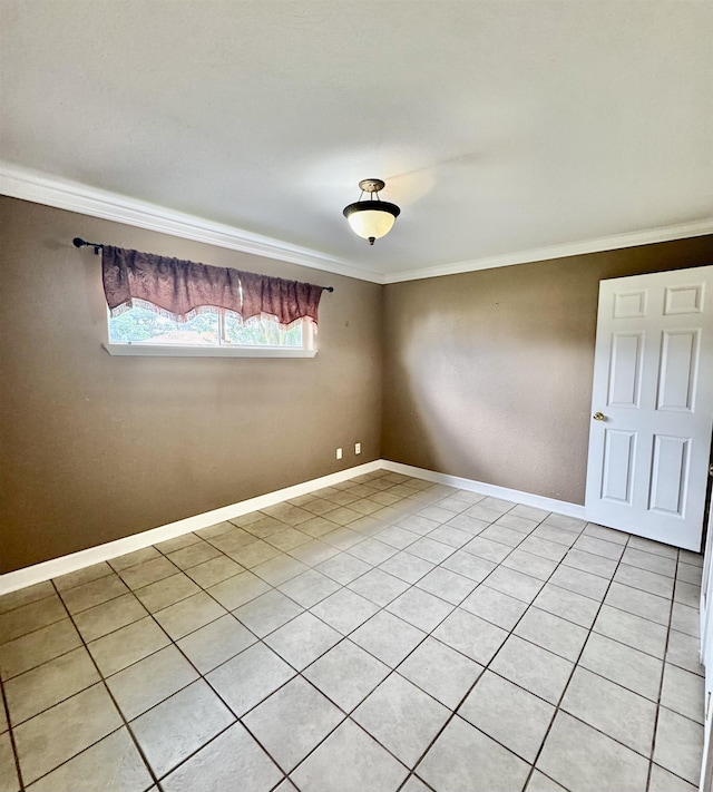 spare room featuring baseboards, ornamental molding, and light tile patterned floors