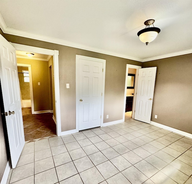 unfurnished bedroom with light tile patterned floors, baseboards, and crown molding