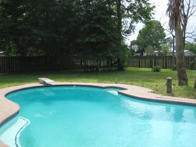 view of swimming pool with a lawn