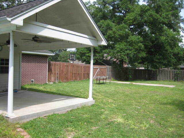 view of yard featuring ceiling fan and a patio