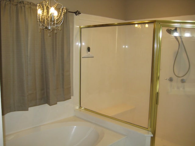 bathroom featuring independent shower and bath and a notable chandelier