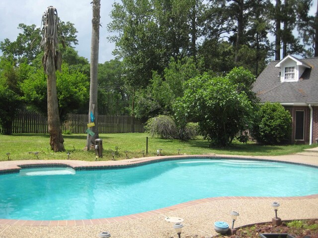 view of pool with a yard