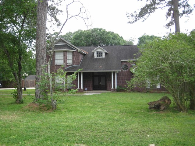 view of front of home with french doors and a front lawn