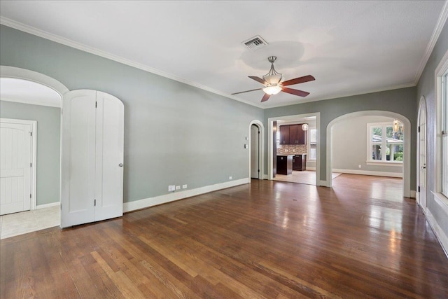 145 Manor St, Beaumont, TX 77706 - unfurnished living room with arched walkways, a ceiling fan, wood finished floors, and ornamental molding