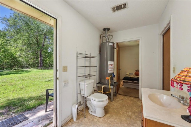 bathroom featuring vanity, water heater, visible vents, and toilet