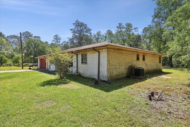 view of property exterior featuring central AC unit, brick siding, a yard, and a garage