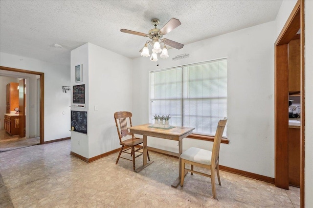 dining area featuring a textured ceiling, baseboards, and a ceiling fan