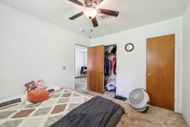 bedroom with a closet, visible vents, a ceiling fan, a textured ceiling, and carpet floors