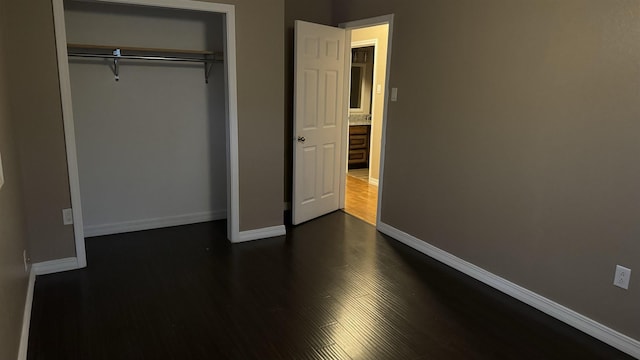 unfurnished bedroom featuring dark hardwood / wood-style flooring and a closet