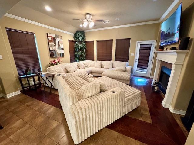 9265 N Sage, Beaumont, TX 77713 - tiled living room featuring a fireplace, a ceiling fan, and ornamental molding