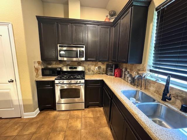 9265 N Sage, Beaumont, TX 77713 - kitchen featuring stainless steel appliances, tasteful backsplash, light tile patterned floors, light countertops, and dark brown cabinets