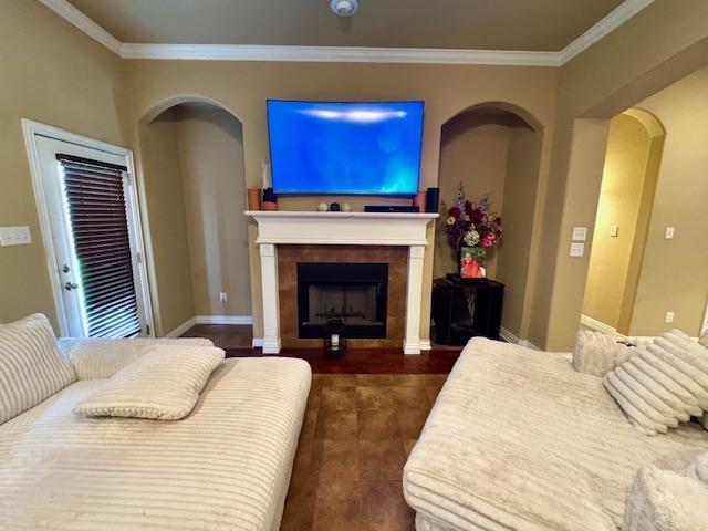 9265 N Sage, Beaumont, TX 77713 - bedroom with crown molding, a fireplace, arched walkways, and dark tile patterned floors
