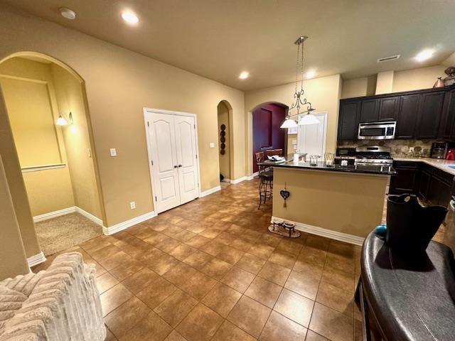9265 N Sage, Beaumont, TX 77713 - kitchen featuring stainless steel appliances, arched walkways, backsplash, pendant lighting, and recessed lighting
