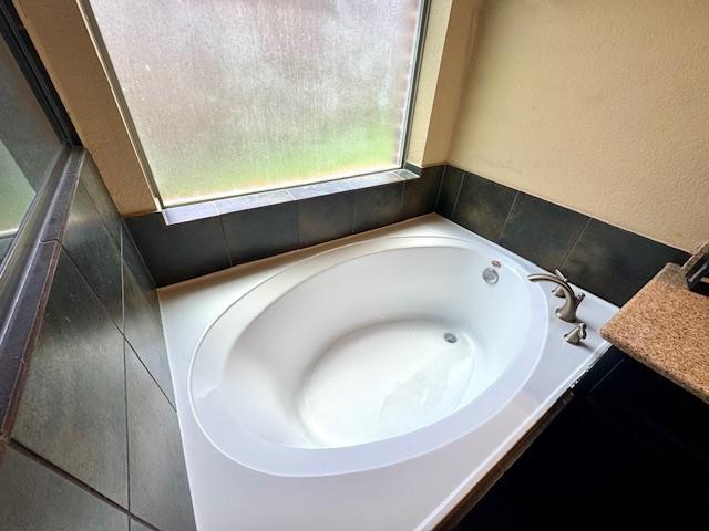 9265 N Sage, Beaumont, TX 77713 - bathroom with plenty of natural light, a bath, and vanity