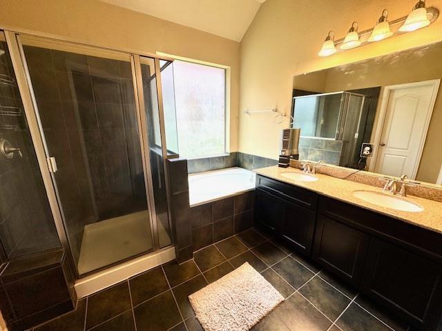 9265 N Sage, Beaumont, TX 77713 - bathroom featuring a shower stall, tile patterned floors, double vanity, a garden tub, and vaulted ceiling