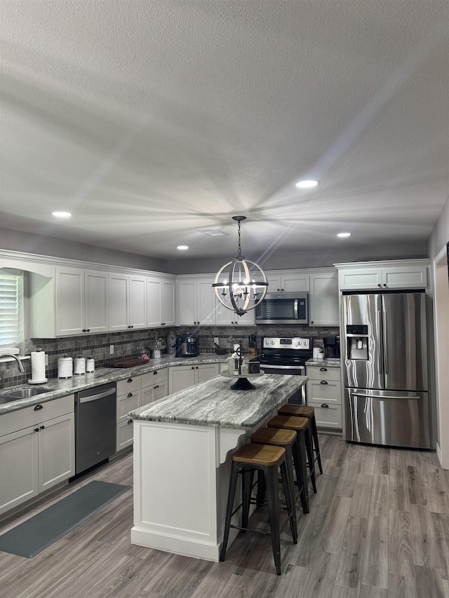 2211 Summer Oak Ln, Orange, TX 77632 - kitchen featuring appliances with stainless steel finishes, backsplash, wood finished floors, white cabinetry, and recessed lighting