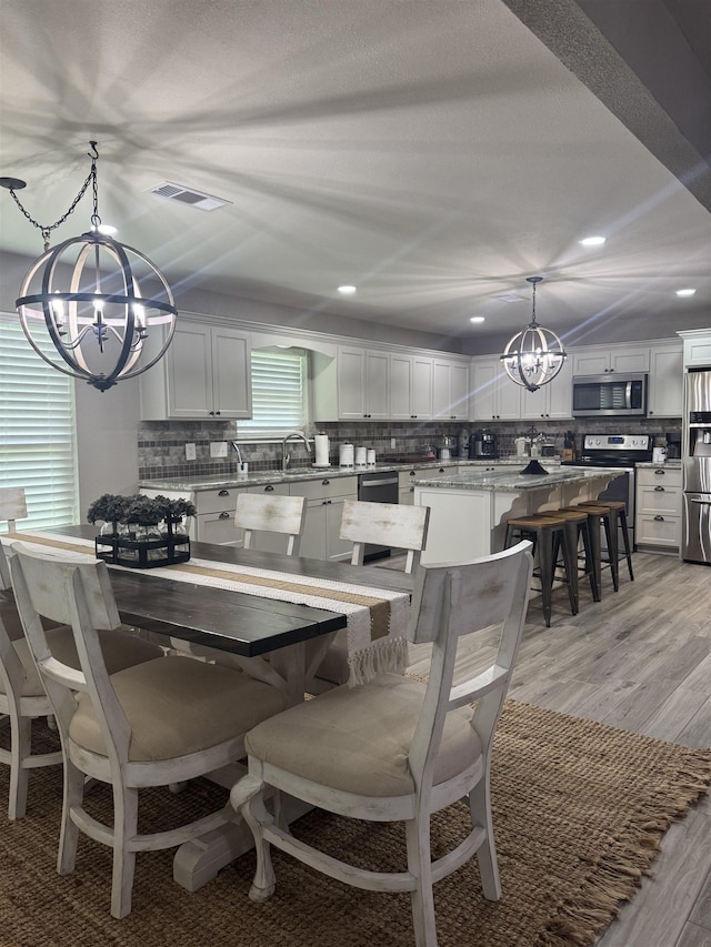 2211 Summer Oak Ln, Orange, TX 77632 - dining room with a chandelier, light wood finished floors, and recessed lighting