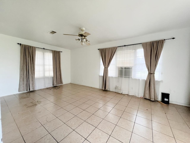 tiled spare room with ceiling fan