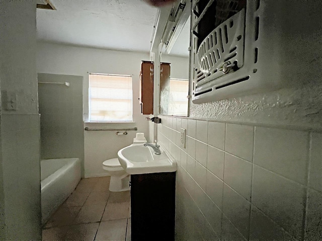 bathroom featuring tile patterned floors, backsplash, toilet, vanity, and tile walls