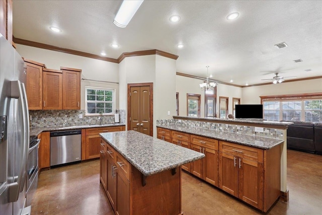 1291 Beachrock Dr, Brookeland, TX 75931 - kitchen with appliances with stainless steel finishes, brown cabinets, open floor plan, a ceiling fan, and crown molding