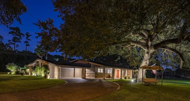 ranch-style house featuring a lawn and a garage