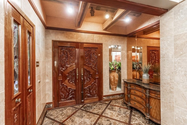 entryway with beamed ceiling and tile walls