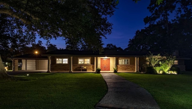 ranch-style house featuring a garage and a front lawn