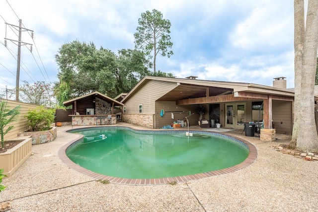 view of swimming pool with french doors and a patio