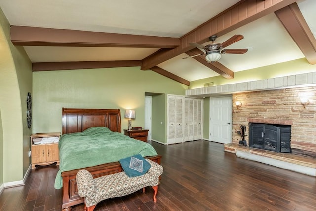 bedroom featuring hardwood / wood-style floors, a stone fireplace, and ceiling fan