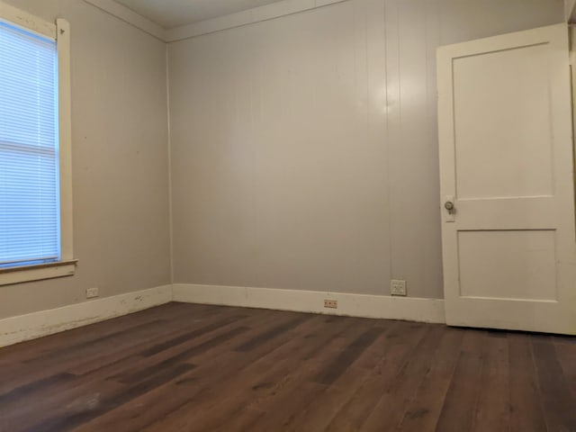 unfurnished room featuring crown molding and dark wood-type flooring