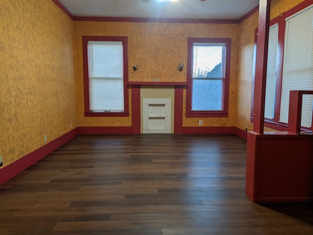 unfurnished living room featuring dark wood-type flooring and ornamental molding