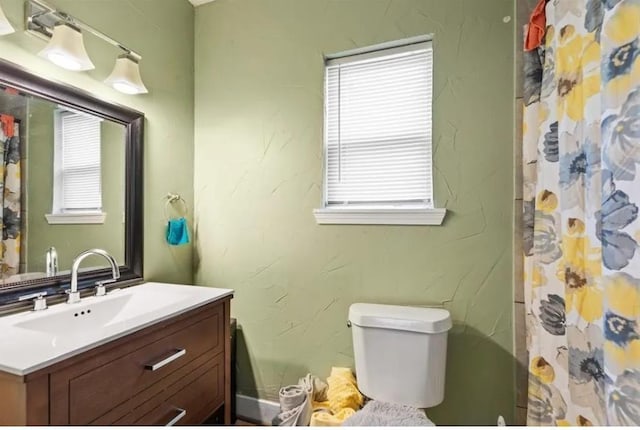 bathroom featuring vanity, curtained shower, and toilet