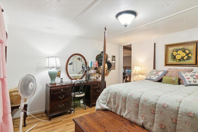 bedroom with light hardwood / wood-style floors and a textured ceiling