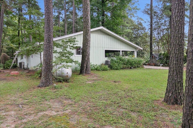 view of side of property featuring a lawn and central air condition unit