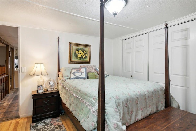 bedroom featuring a closet, wood-type flooring, and a textured ceiling